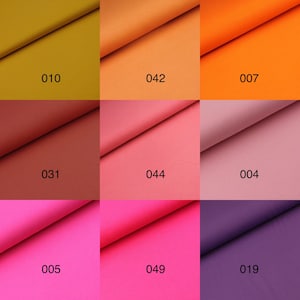 May include: Nine fabric swatches in different colors, including mustard yellow, orange, coral, pink, and purple. Each swatch has a number printed on it, such as "010", "042", "007", "031", "044", "004", "005", "049", and "019".