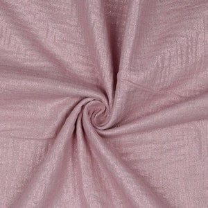 May include: A close-up of a soft, pink fabric with a subtle shimmer. The fabric is folded and draped, showcasing its texture and drape.