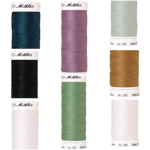 Può includere: Sei bobine di filo di diversi colori, tra cui verde acqua, viola, verde chiaro, marrone, nero e bianco. Ogni bobina è etichettata "KUP Mettler" e ha il numero "No. 100" stampato su di essa.