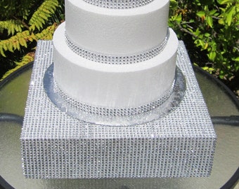 Hochzeitstortenständer, 16" x 4" (40 cm x 10 cm), quadratische Erhöhungsplattform, silberfarbenes glitzerndes Strassgeflecht an den Seiten und oben, Styropor
