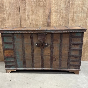 May include: A large wooden chest with metal accents and a hinged lid. The chest is made of reclaimed wood and has a rustic, weathered look.