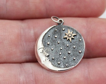May include: A silver charm with a crescent moon design and a gold star. The moon is textured with small dots and the star is in the center of the moon.