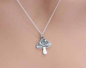 May include: A silver necklace with a mushroom pendant. The mushroom is detailed with a moon and stars.