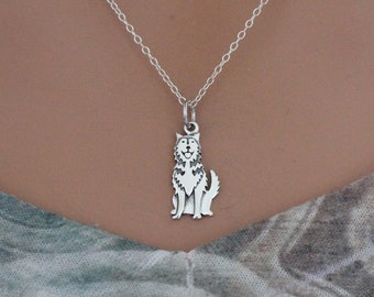 May include: A silver chain necklace with a silver pendant of a wolf sitting down.