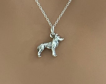 May include: A silver chain necklace with a small, detailed silver wolf pendant.