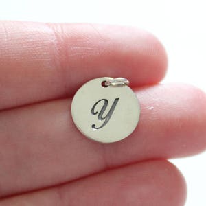 May include: Silver charm with the letter 'y' engraved on it.