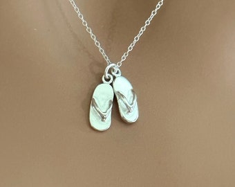 May include: A silver chain necklace with a pair of silver flip-flop charms.
