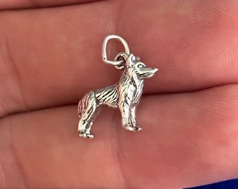 May include: A silver charm in the shape of a standing dog. The charm has a detailed design and is perfect for adding a touch of personality to a necklace or bracelet.