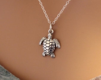 May include: A silver chain necklace with a small silver turtle pendant.