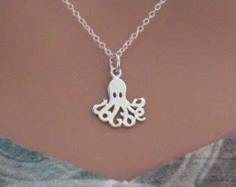 Puede incluir: Un collar de plata con un delicado colgante de pulpo. El colgante es un diseño de corte, que muestra los tentáculos del pulpo.