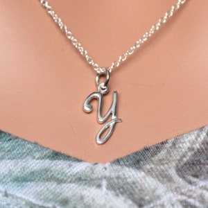 May include: A silver chain necklace with a cursive letter Y pendant.