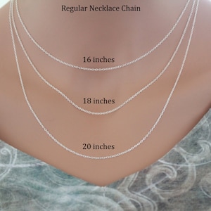 May include: Three silver necklace chains of different lengths, 16 inches, 18 inches, and 20 inches, displayed on a model's neck.