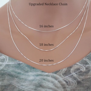 May include: Three silver necklace chains of different lengths, 16 inches, 18 inches, and 20 inches, displayed on a mannequin.