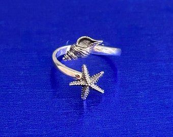 May include: Silver ring with a seashell and starfish design. The ring is adjustable and open ended.