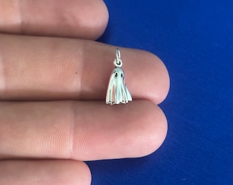 May include: A silver charm in the shape of a ghost. The ghost has two small eyes and a rounded body.