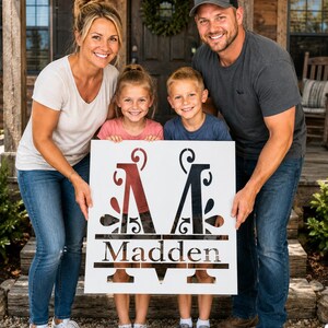 May include: A square white stencil featuring a large decorative letter M with intricate scrollwork details. Below the letter, the name Madden is displayed in a clear serif font, framed by horizontal lines that extend across the width of the stencil.