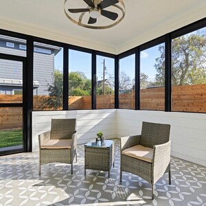 May include: Two wicker chairs with cushions and a small wicker table with a potted plant on a tiled floor in a screened-in porch.