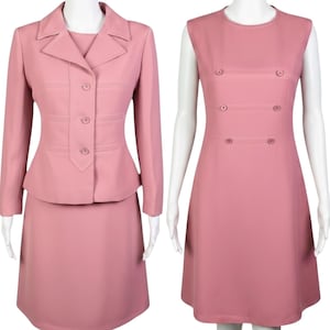 May include: A dusty rose two-piece suit consisting of a long-sleeved jacket with three front buttons and a matching skirt, alongside a sleeveless knee-length dress in the same dusty rose color featuring six decorative buttons in three rows.