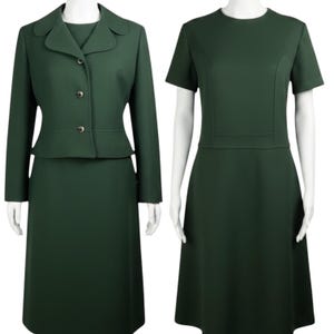 May include: A dark green two-piece suit consisting of a long-sleeved jacket with three buttons and a matching skirt, alongside a dark green short-sleeved dress with a round neckline and a defined waistline, both displayed on white mannequins.