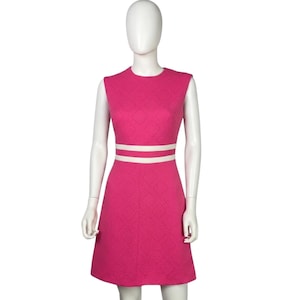 May include: A sleeveless, knee-length dress in a vibrant fuchsia pink hue. The fabric features a subtle, raised diamond-shaped geometric texture throughout. Two horizontal white bands encircle the waist, creating a distinct contrast.