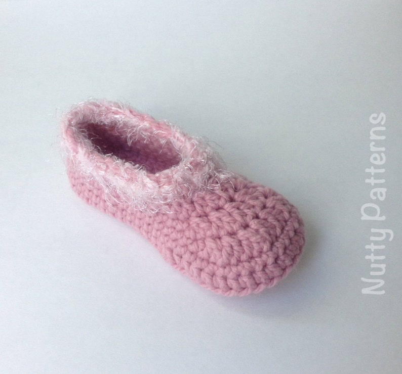 May include: Pink crocheted slipper with a white fuzzy trim around the opening. The slipper is made with a single crochet stitch.