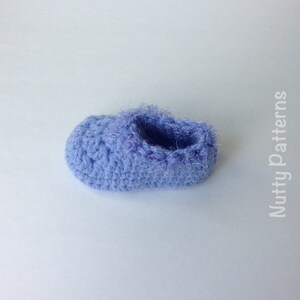 May include: A pair of light blue crocheted baby booties with a fuzzy trim around the opening.