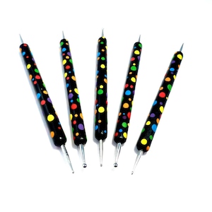 以下が含まれることがあります： 異なる金属製の先端を持つ、黒と虹色の水玉模様の彫刻ツール5本セット。