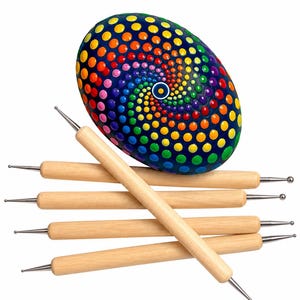 May include: A smooth, oval-shaped stone painted with a vibrant, multi-colored spiral dot pattern in shades of red, orange, yellow, green, blue, and purple, accompanied by five wooden dotting tools with metal ball tips at each end.