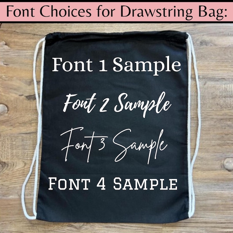 May include: A black drawstring bag with white text displaying font samples. The text includes "Font 1 Sample," "Font 2 Sample," "Font 3 Sample," and "FONT 4 SAMPLE." The bag has white drawstrings and is set against a wooden background.