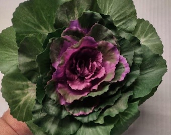 Puede incluir: Un repollo artificial grande con hojas verde oscuro y un centro morado y verde.
