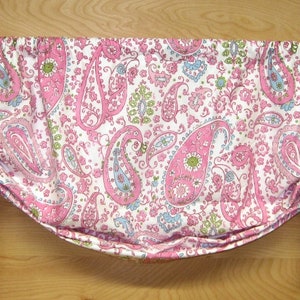 May include: A pink and white paisley patterned valance with a gathered design. The valance has a white background with pink, blue, and green paisley patterns.