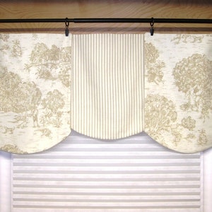 May include: A three-panel valance with a cream background and a beige pattern. The center panel features vertical stripes, while the side panels have a toile-like pattern of trees and houses.