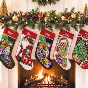 May include: Five personalized Christmas stockings hanging in a row. Each stocking features a red cuff with a name embroidered in white: Mom, Dad, Claus, LUCAS, and Do. The stockings display colorful holiday scenes including Santa, toys, and trees.
