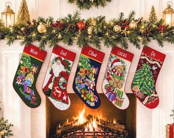 May include: Five personalized Christmas stockings hanging in a row. Each stocking features a red cuff with a name embroidered in white: Mom, Dad, Claus, LUCAS, and Do. The stockings display colorful holiday scenes including Santa, toys, and trees.