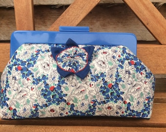 Blue floral clutch purse with blue resin handle, internal pocket and hand. made barkcloth fabric flower decoration.