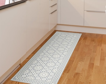 Puede incluir: Un tapete de cocina gris y blanco con un diseño geométrico. El tapete está colocado en una cocina con gabinetes blancos y un piso de madera.