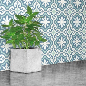 May include: A gray concrete planter with a green plant inside, sitting on a countertop with a blue and white patterned tile backsplash.