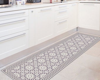 Puede incluir: Una cocina blanca con armarios blancos y una alfombra de corredor gris y blanca con estampado en el suelo.