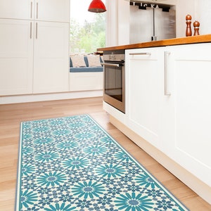 Puede incluir: Una alfombra de cocina azul y blanca con un diseño geométrico. La alfombra se coloca delante de una isla de cocina blanca con una encimera de madera.