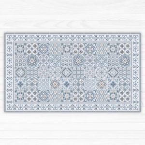 Könnte beinhalten: Ein blauer und weißer Teppich mit geometrischem Muster. Der Teppich hat einen Rand mit kleinen floralen Motiven.