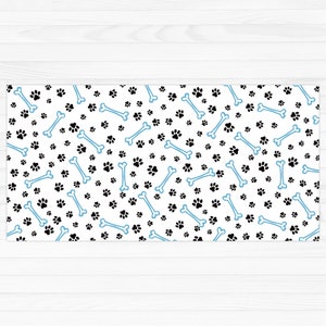 Op de afbeelding: Een witte achtergrond met een herhalend patroon van zwarte poot afdrukken en blauwe botvormen.