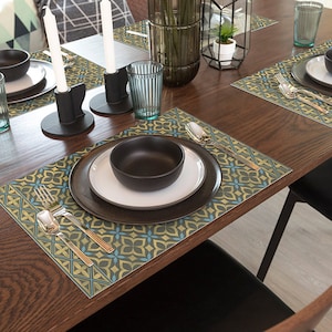 May include: A wooden dining table set with four place settings. Each place setting includes a black bowl, a white plate, a black plate, a fork, a knife, and a glass. The table is decorated with green and gold placemats with a geometric pattern.