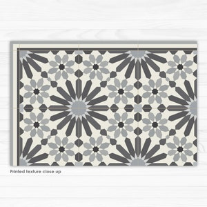 May include: A black and white geometric tile pattern with a repeating starburst design. The tile is made of ceramic and has a glossy finish.