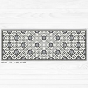 May include: A gray and white geometric patterned runner rug with a floral design. The rug is 80x220 cm or 32x86 inches.