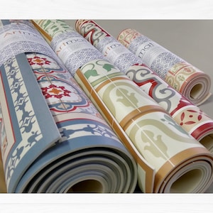 May include: Four rolled up floor mats with a tile pattern. The mats are in various colors, including blue, green, red, and white. The mats are labeled "Artmat".