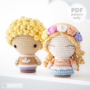 May include: Two crocheted dolls, one with yellow hair and a brown shirt, the other with blonde hair and a flower crown, wearing a peach and blue dress.  PDF pattern only.