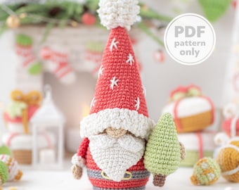 May include: A handmade crochet gnome with a red hat adorned with white stars and a fluffy white pom-pom. The gnome has a white beard, a gray belt, and is holding a small green Christmas tree. The image includes the text "PDF pattern only".