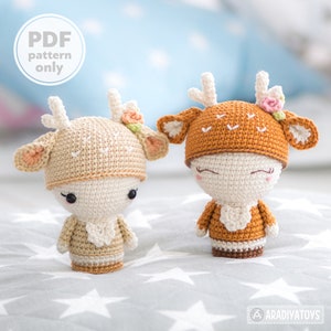 Könnte beinhalten: Zwei gehäkelte Amigurumi-Spielzeugtiere in Form von Rehen aus braunem und beigefarbenem Garn. Das Reh links trägt einen beigefarbenen Hut mit einer Blume, das Reh rechts einen braunen Hut mit einer Blume. Beide Rehe haben gestickte Augen und Nasen.