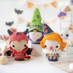 May include: Three crocheted dolls featuring a red devil with horns and wings, a green gnome with a beard and stitches on its hat, and a clown with orange hair, a grey hat, and a white balloon. The logo ARADIYATOYS is visible in the top corner.