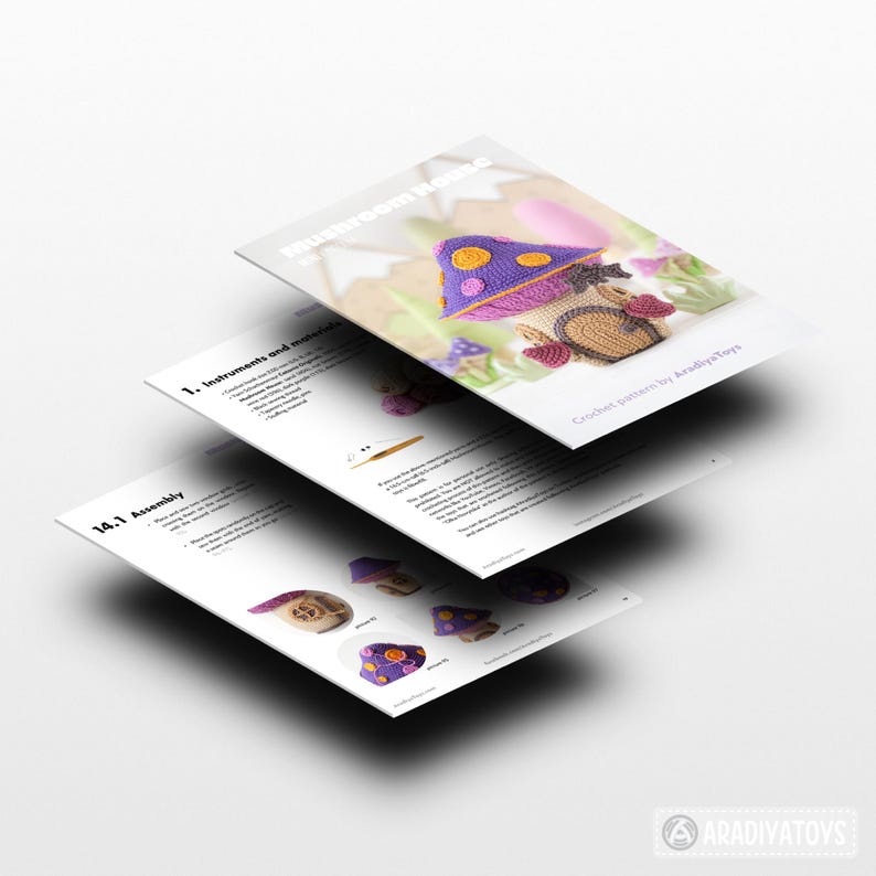 May include: A stack of three white papers with the title "Mushroom House" and crochet pattern instructions. The top paper shows a crocheted mushroom house with a purple roof and brown base. The text "Crochet pattern by AradiyaToys" is also visible.